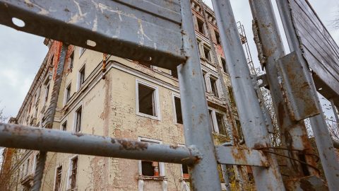 Разрушающееся бывшее общежитие по улице Космонауди, 6 в Нарве обнесено забором и замок висит на воротах, но это не спасает от проникновения туда безответственных подростков. (Фото: Илья СМИРНОВ/АРХИВ)